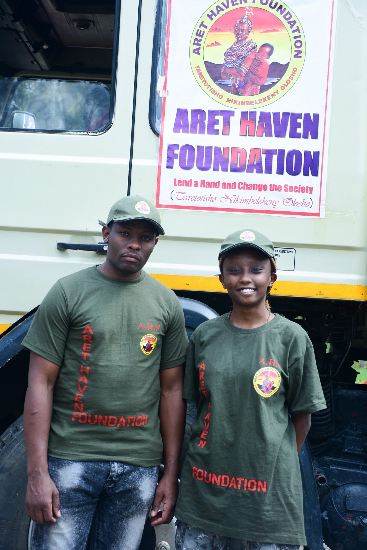 Aret Haven Foundation team members in branded shirts beside the outreach truck